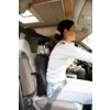 Persona con maglia bianca e jeans chiari, allacciata, seduta al volante di un'auto; seggiolino sul sedile posteriore