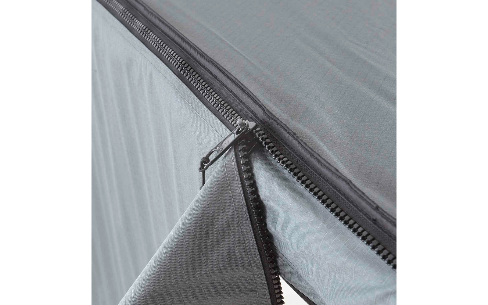 Nahaufnahme eines halb geöffneten Reißverschlusses an hellem Stoff mit feinem Karomuster