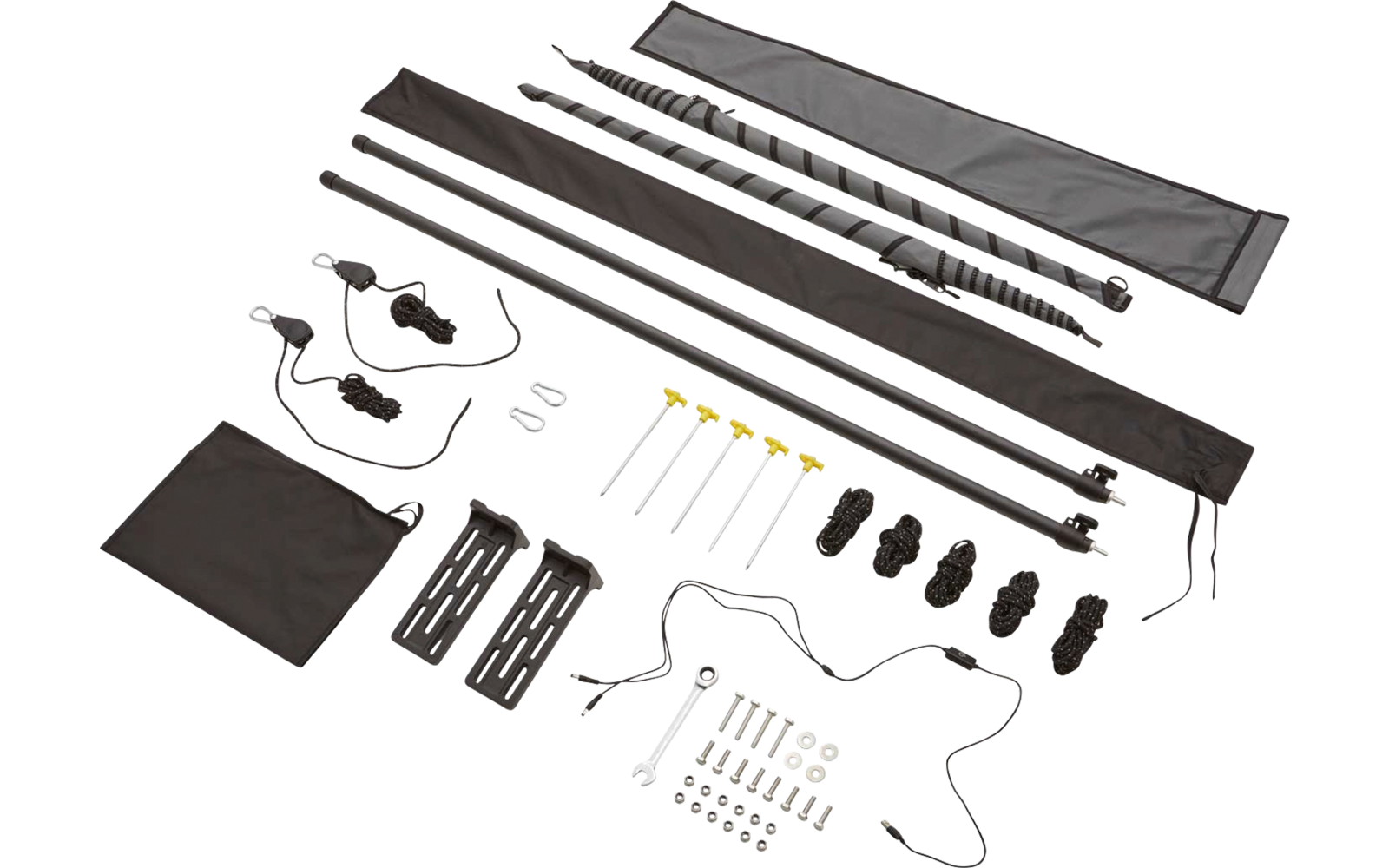 Mehrere schwarze Stangen und Stangenstücke, ein spiralförmiges Metallteil, zwei lange Stoffhüllen, Gurte mit Schnallen, metallische Stifte mit gelben Köpfen, mehrere schwarze Kunststoffclips, ein quadratisches schwarzes Tuch und verschiedene kleine M