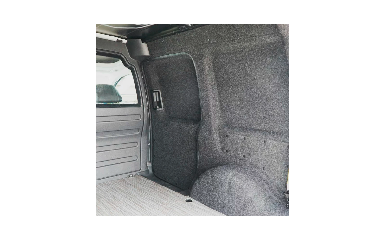 Innenraum eines Lieferwagens mit grauer Filzverkleidung, Radkasten, Trennwand mit kleinem Fenster und hellem Holzfußboden