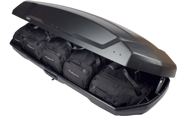 Geöffnete schwarze Dachbox mit vier schwarzen Taschen im Inneren