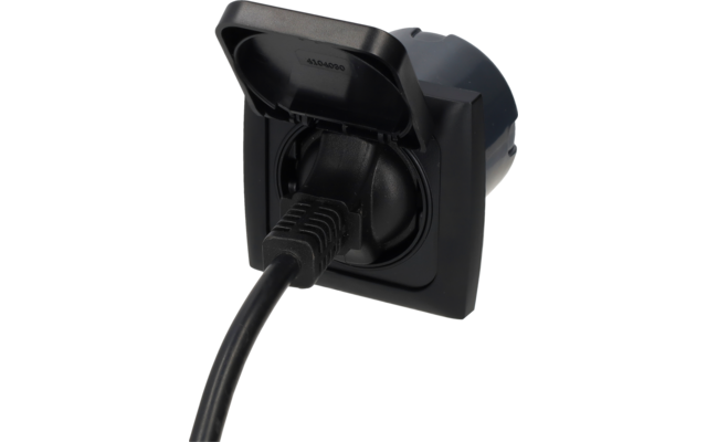 Black recessed outlet with open hinged cover and a black plug with cable inserted