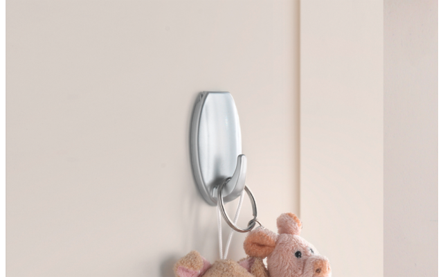 Ein schlichter Wandhaken mit einem Schlüsselanhänger und einem kleinen Plüschbär