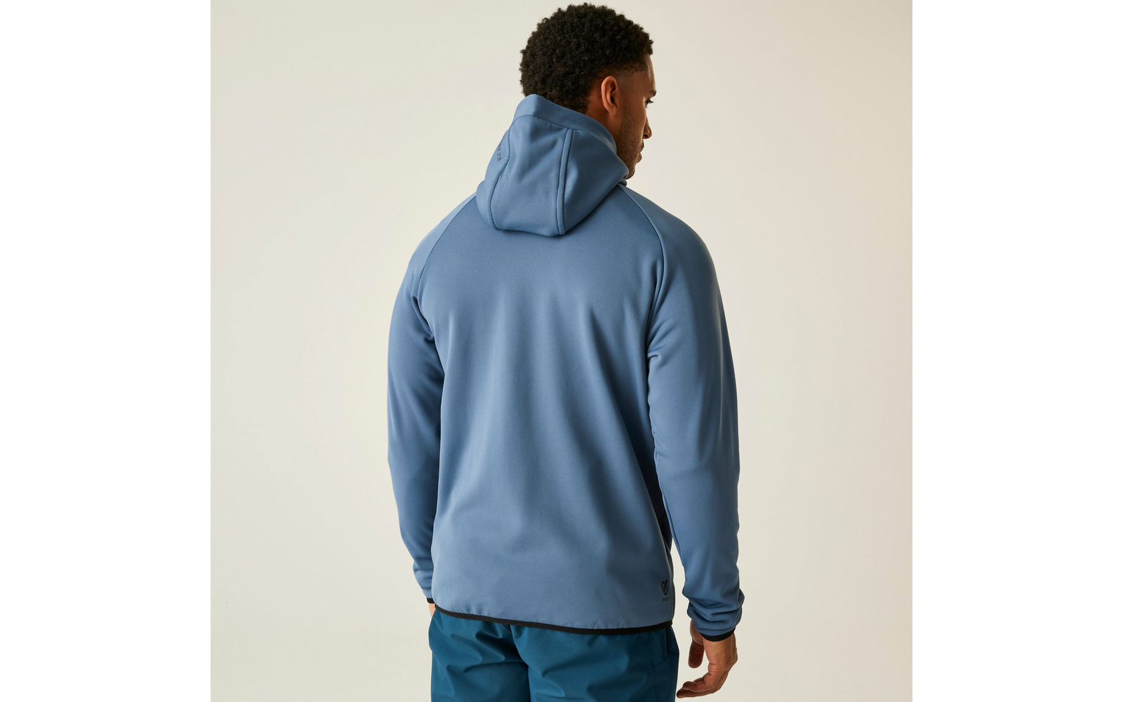 Mann von hinten, trägt einen blauen Kapuzenpullover und blaue Hosen