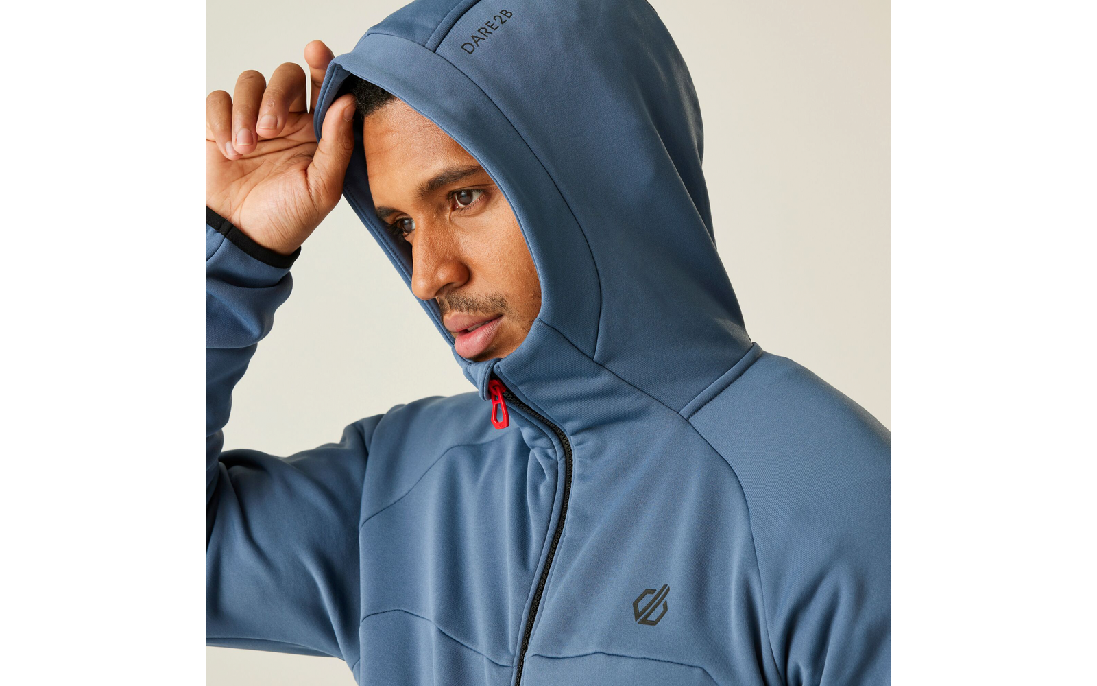 Mann mit blauer Kapuzenjacke, der die Kapuze anfasst