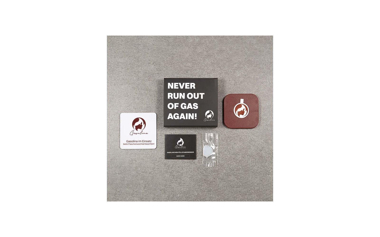 Auf grauem Untergrund ein schwarzer Karton mit weißer Aufschrift 'NEVER RUN OUT OF GAS AGAIN!', links eine weiße quadratische Karte mit rundem Flammenlogo und Text, rechts ein brauner Untersetzer mit demselben Logo, unten eine kleine schwarze Karte m