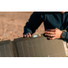 Person hält ein faltbares Solarpanel im Freien