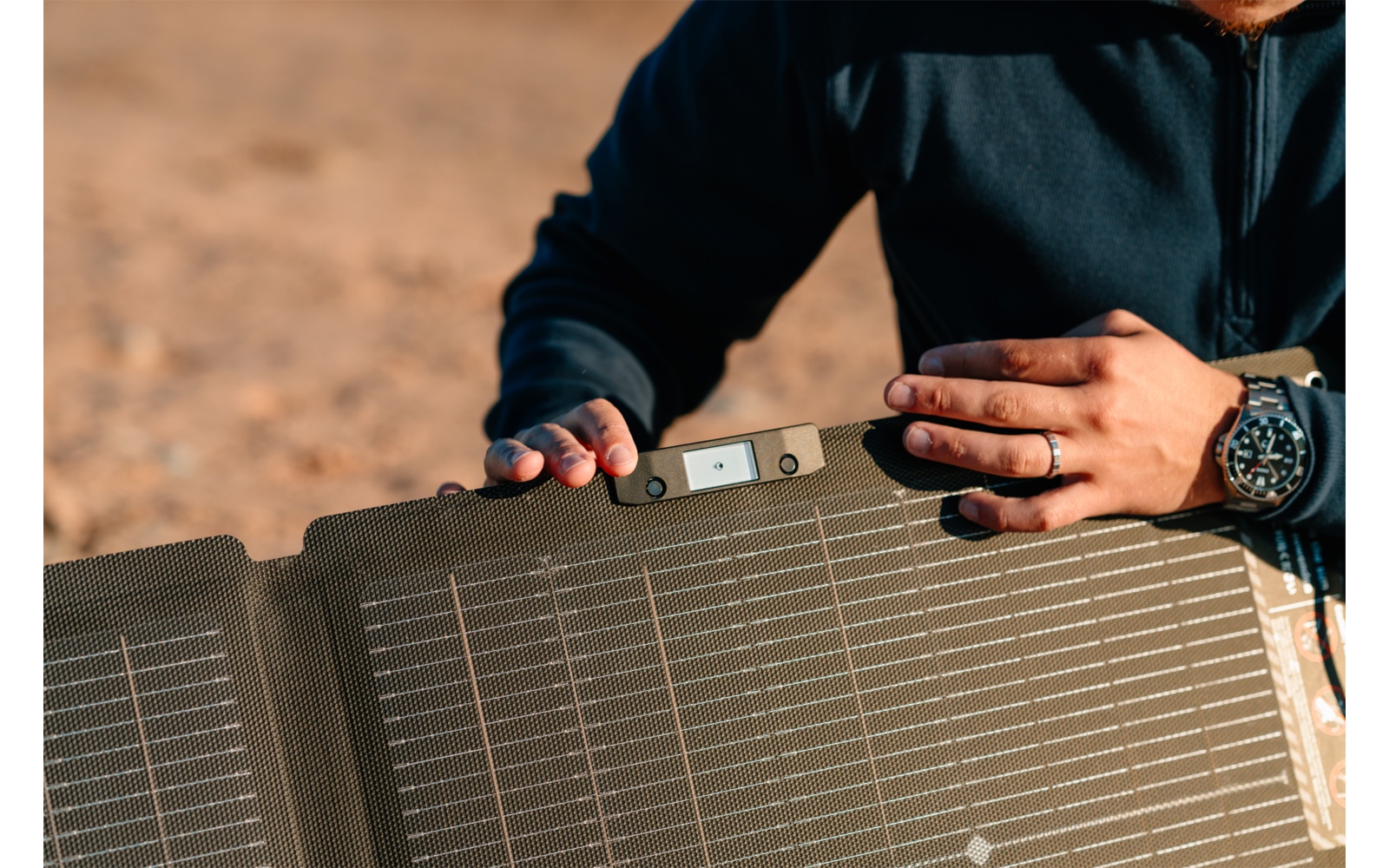 Person hält ein faltbares Solarpanel im Freien
