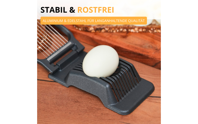 Trancheur d'œuf avec un œuf écalé sur une planche en bois; texte en arrière-plan 'STABIL & ROSTFREI' et étiquette jaune 'ALUMINIUM & EDELSTAHL FÜR LANGANHALTENDE QUALITÄT'