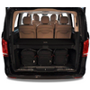 Arrière ouvert d'une camionnette noire avec trois sièges en cuir beige, une tablette de coffre et trois sacs à dos noirs dans le coffre