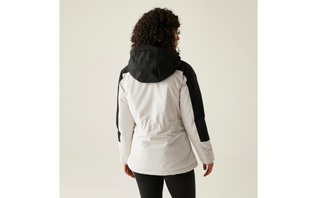 Vrouw met krullend haar die een witte jas met zwarte mouwen draagt, gefotografeerd van achteren