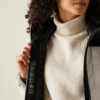 Frau mit lockigem Haar, die einen Pullover und eine Jacke trägt