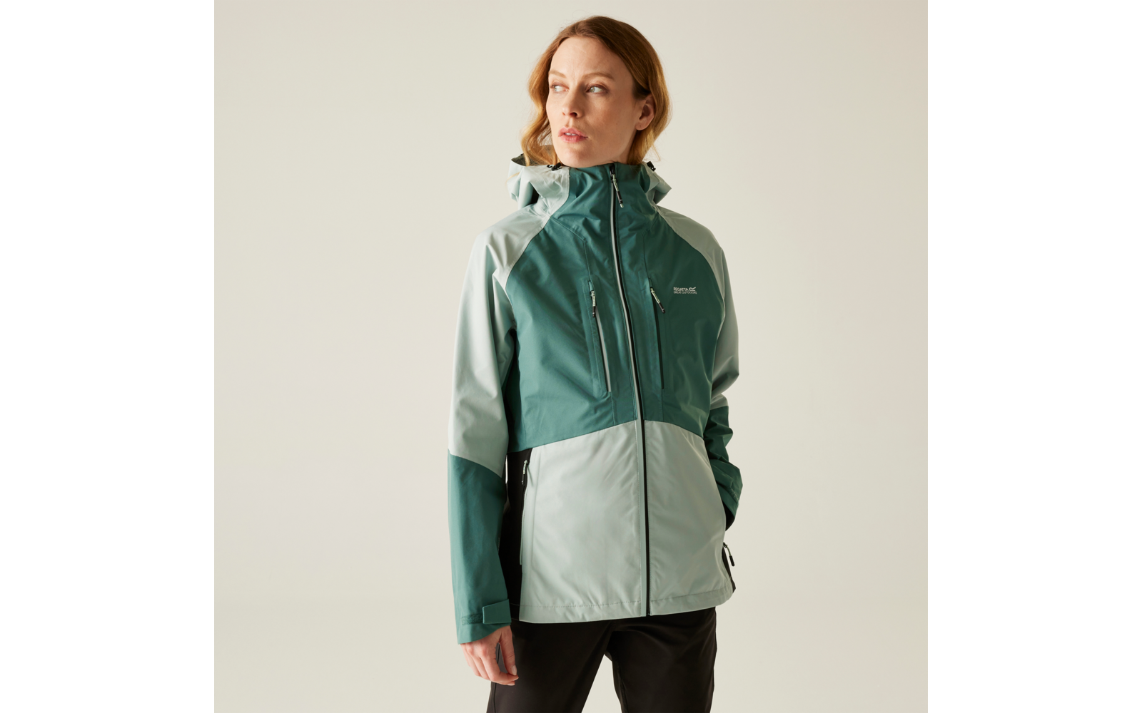 Frau trägt grüne und hellgraue Outdoorjacke mit Kapuze