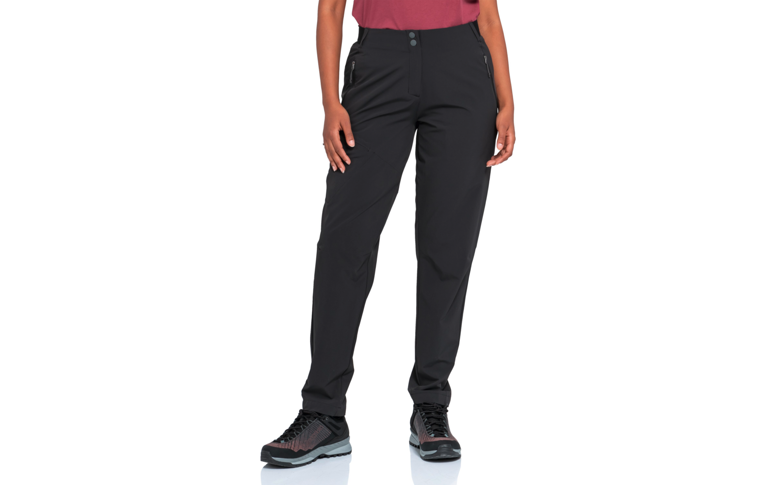 Stehende Person, nur Unterkörper sichtbar, schwarze Hose, schwarze Sportschuhe mit hellgrauer Sohle, Hände seitlich, roter Oberteilansatz oben im Bild