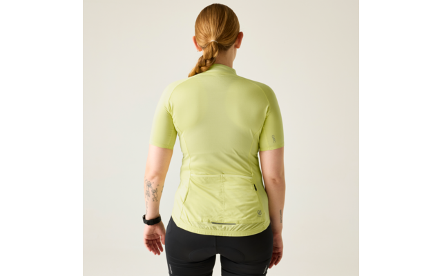 Rückansicht einer Person mit geflochtenem Zopf, hellgrünes kurzärmeliges Oberteil mit Rückentaschen, schwarze Shorts, Tätowierung am linken Unterarm und schwarze Uhr am linken Handgelenk