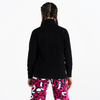Person von hinten mit schwarzem Pullover und pink-weiß gemusterten Hosen