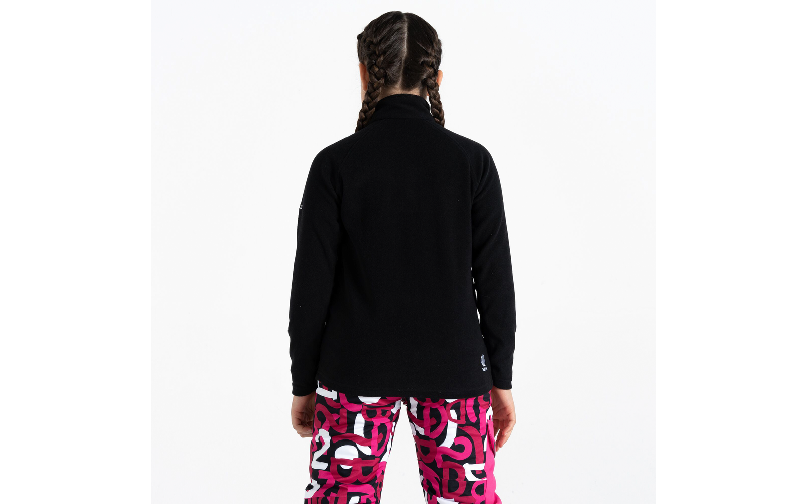 Person von hinten mit schwarzem Pullover und pink-weiß gemusterten Hosen