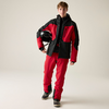 Person in roter und schwarzer Jacke und roter Hose, steht und hält einen schwarzen Helm