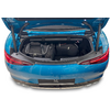 Coffre ouvert d'une voiture de sport bleue contenant trois sacs de voyage noirs