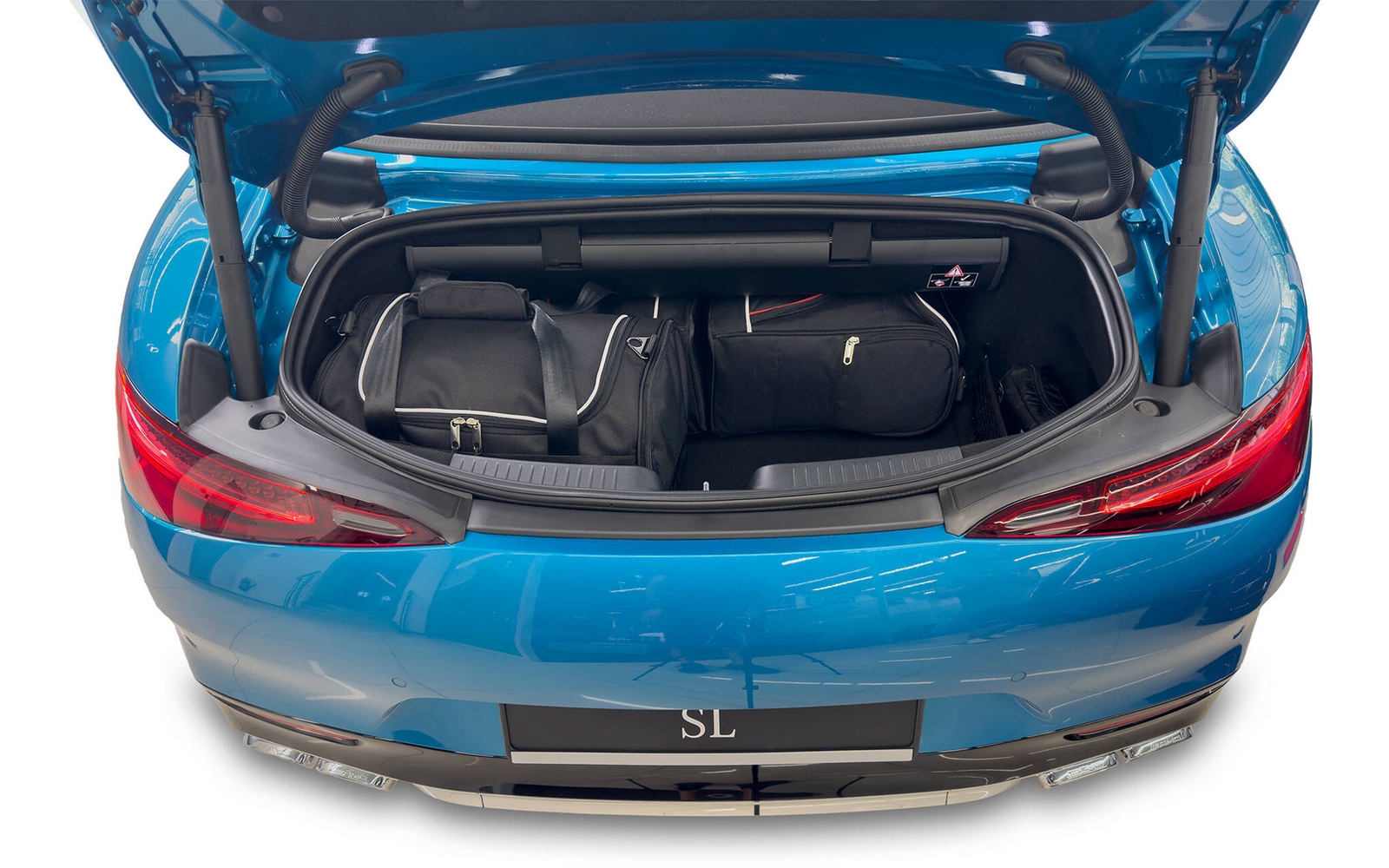 Coffre ouvert d'une voiture de sport bleue contenant trois sacs de voyage noirs