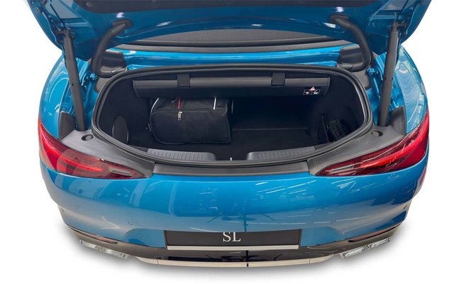 Coffre ouvert d'une voiture bleue avec un sac de voyage noir à l'intérieur; feux arrière visibles
