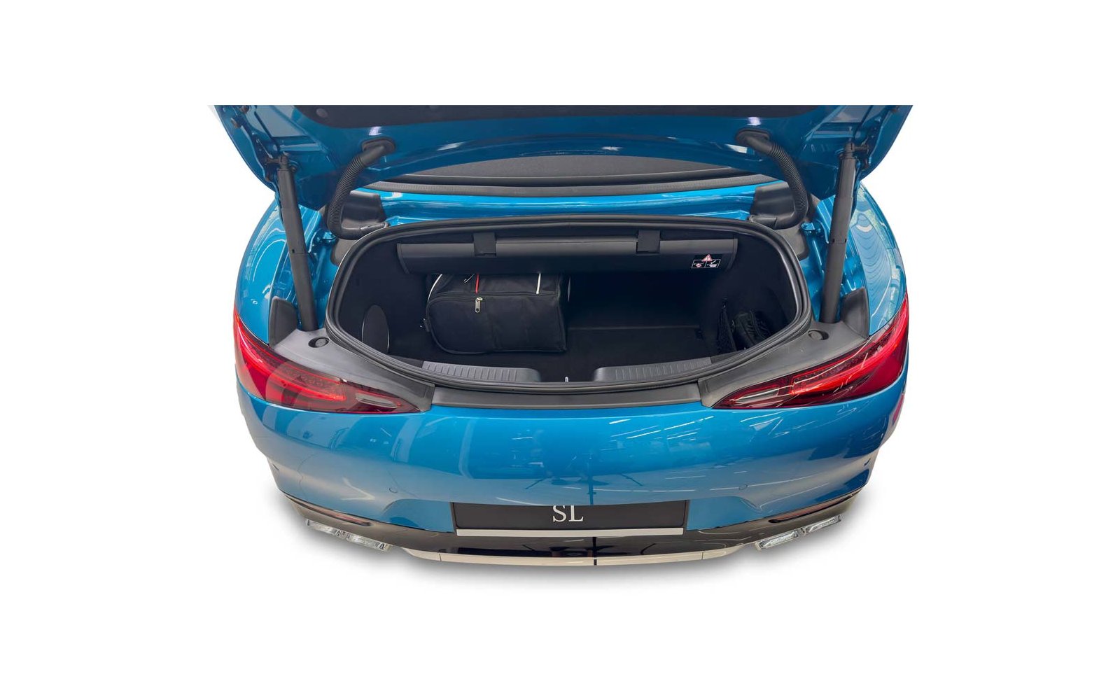 Coffre ouvert d'une voiture bleue avec un sac de voyage noir à l'intérieur; feux arrière visibles