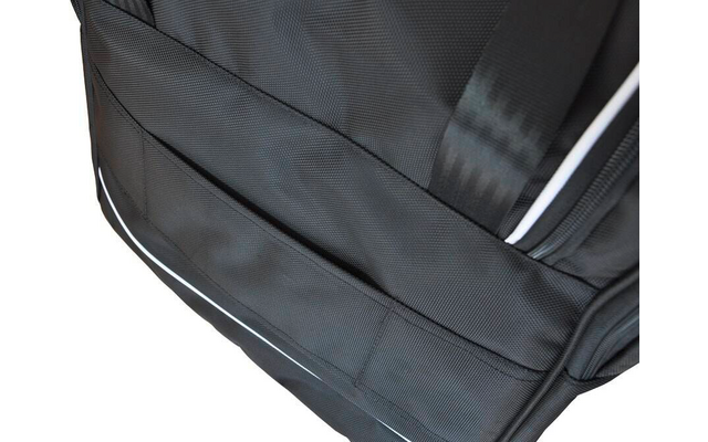 Gros plan d'un sac à dos noir en tissu avec fermeture éclair, sangle et passepoil blanc