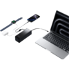 Ein Laptop, ein schwarzes Ladegerät, ein USB-Kabel und ein Kugelschreiber liegen auf einem weißen Tisch
