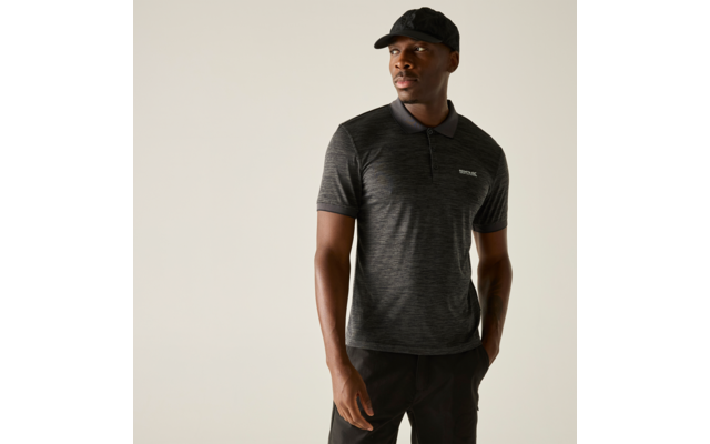 Persoon met donkergrijs kort mouw polohemd met klein borstlogo en zwarte pet, staand voor een effen lichte achtergrond en kijkt opzij