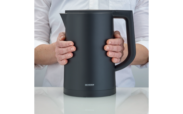 Persona che tiene un bollitore elettrico nero con entrambe le mani su uno sfondo bianco