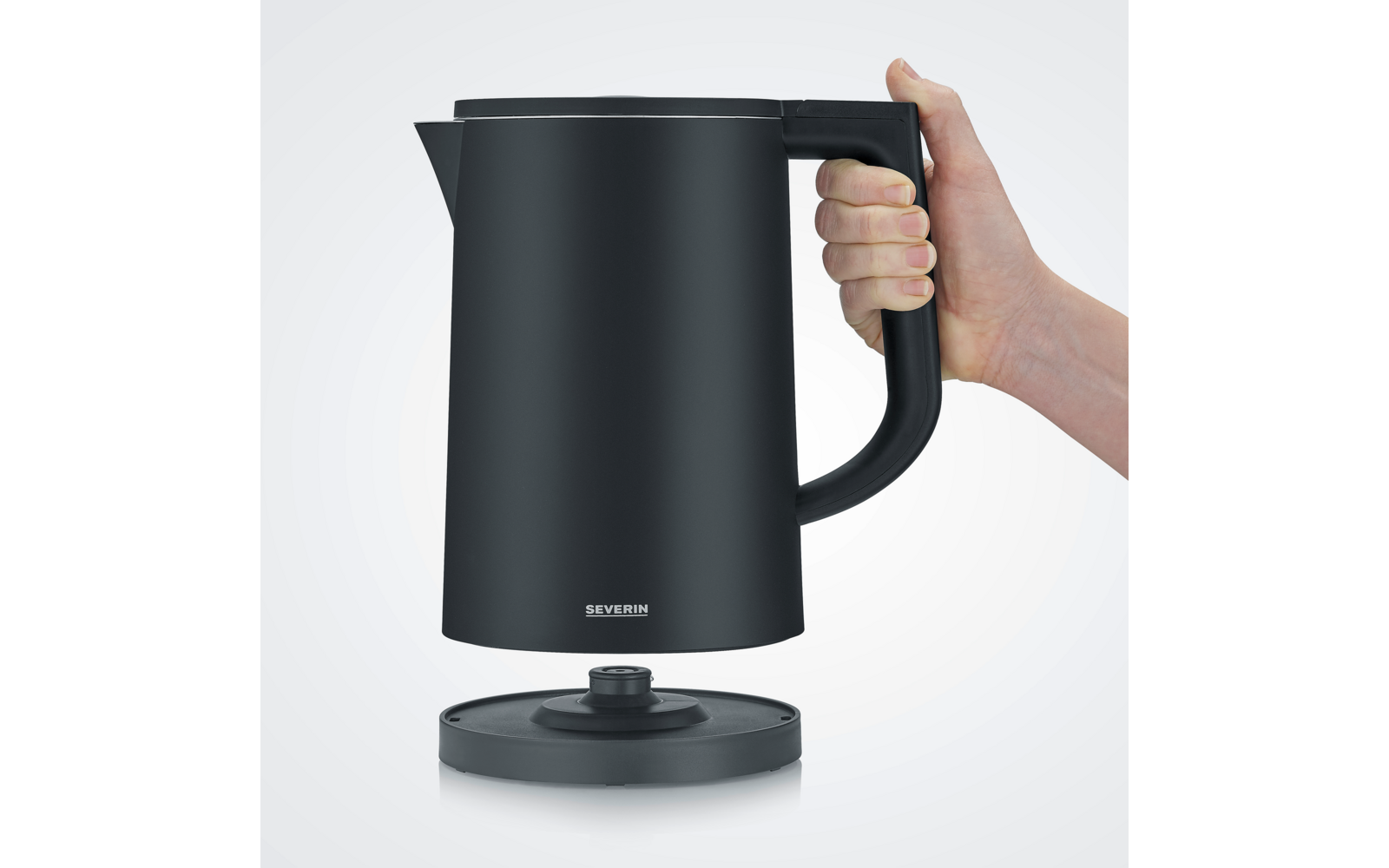 Bollitore elettrico nero su base, tenuto da una mano