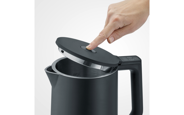 Mano che tocca il coperchio aperto di un bollitore nero