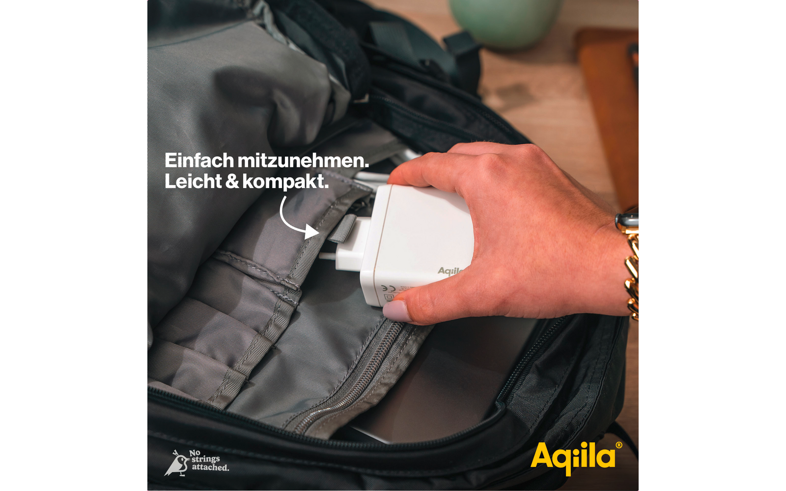 Hand legt eine kleine weiße Packung in eine schwarze Tasche