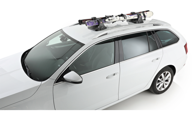 Break blanc vu de trois-quarts dessus, avec une paire de skis fixée sur le porte-bagages de toit