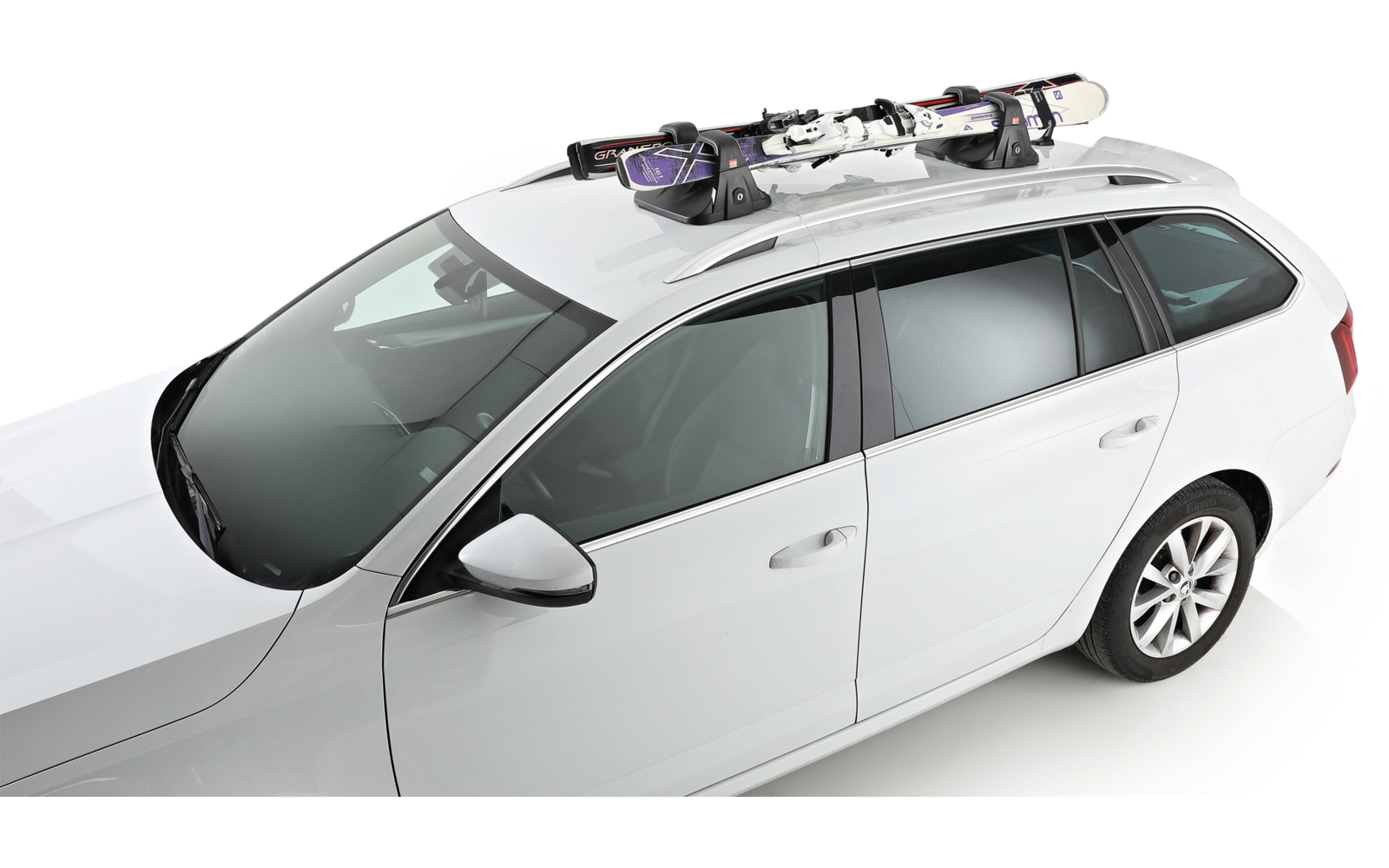 Break blanc vu de trois-quarts dessus, avec une paire de skis fixée sur le porte-bagages de toit