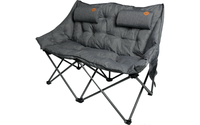 Zweisitzige dunkelgraue gepolsterte faltbare Sitzbank auf schwarzem X-förmigem Metallgestell; gesteppte Oberfläche; zwei zylindrische Kopfkissen mit braunen runden Aufnähern