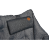 Gray quilted padded surface with a small rectangular cushion at the top edge and a round brown leather patch on the cushion