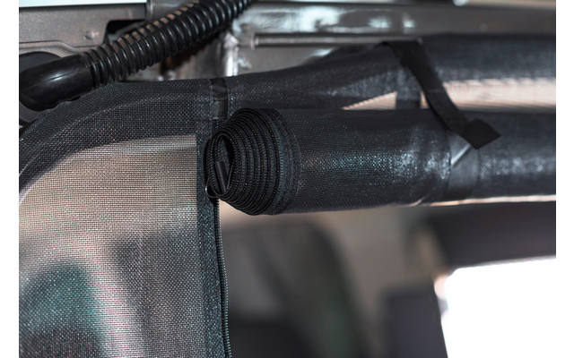 Nahaufnahme eines schwarzen Kunststoffrohrs, das mit Kabelbindern an einem Metallrahmen befestigt ist