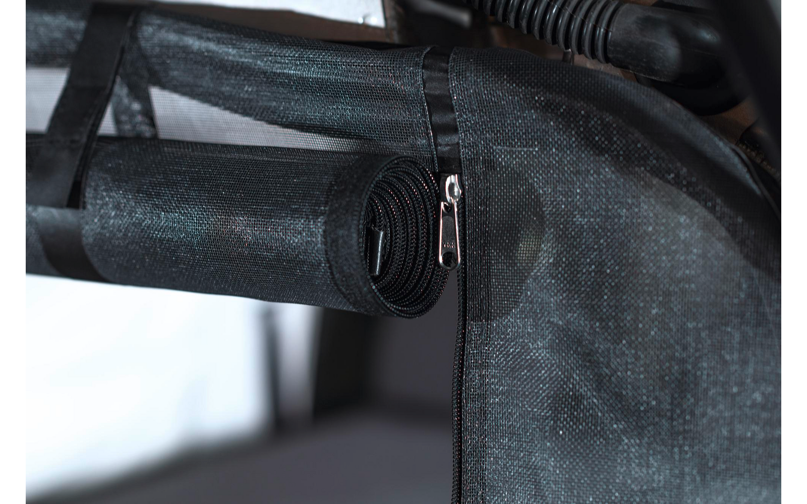 Nahaufnahme eines schwarzen Reißverschlusses an einem grauen Stoff