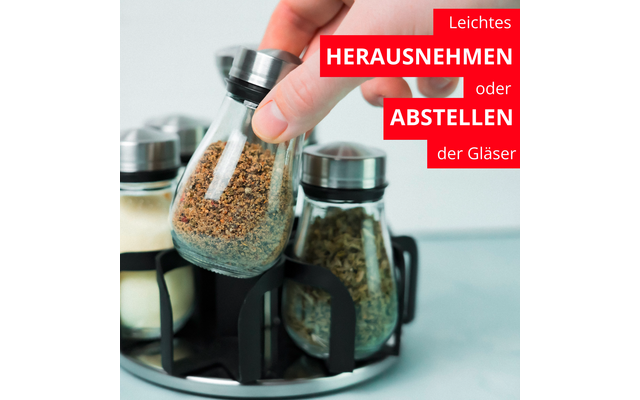 Main soulève un petit bocal en verre avec couvercle métallique d'un porte-épices circulaire; trois bocaux en verre avec différentes épices sont dans des supports; rectangles rouges avec texte allemand blanc 'Leichtes HERAUSNEHMEN oder ABSTELLEN der Gläser'