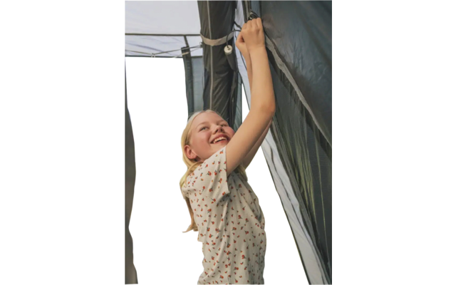 Frau hebt Vorhang in einem Zelt an und schaut hinaus