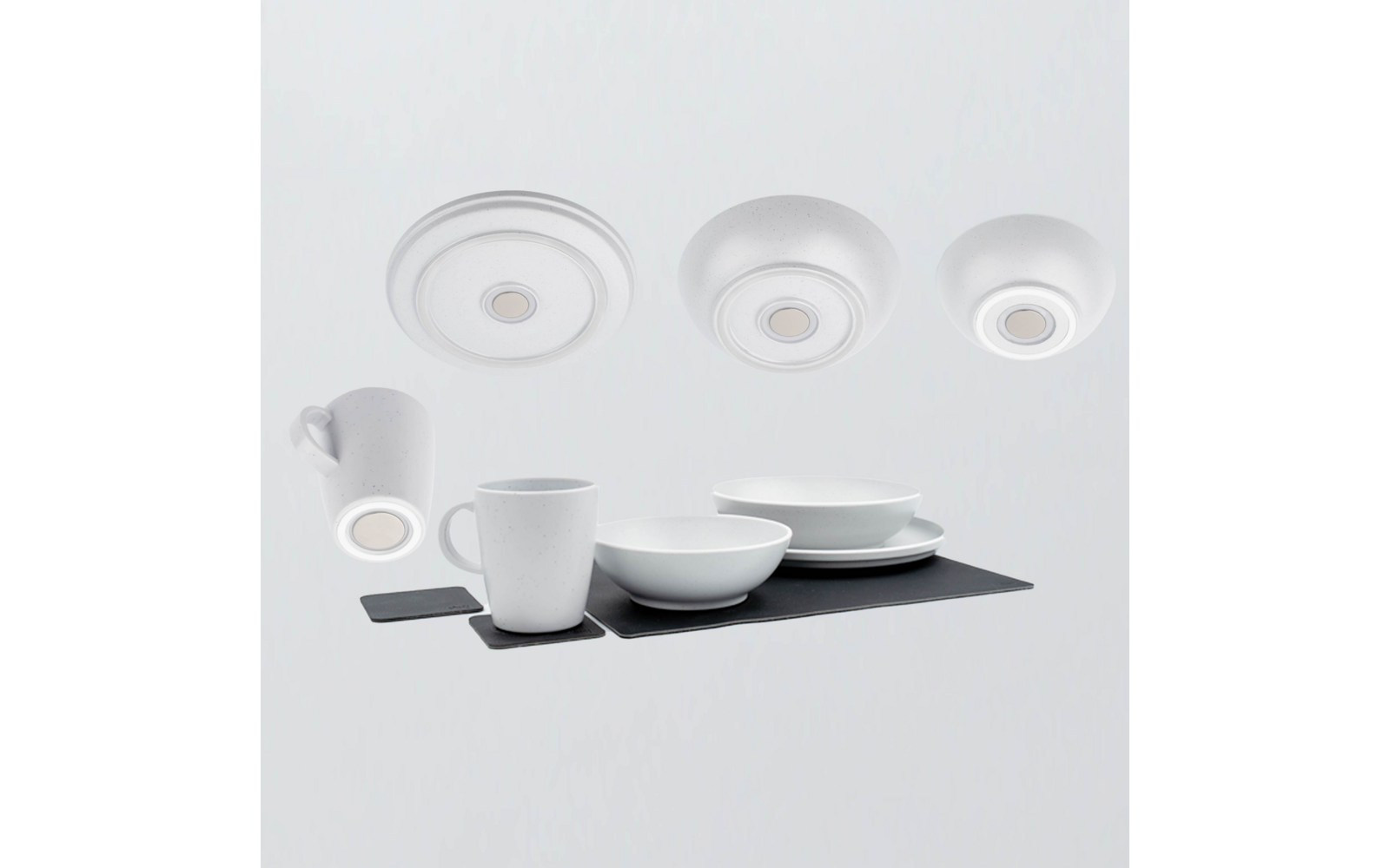 Wit servies op een donker rechthoekig onderlegger: twee mokken, twee kommen, gestapelde borden; drie ronde witte schijven bovenaan