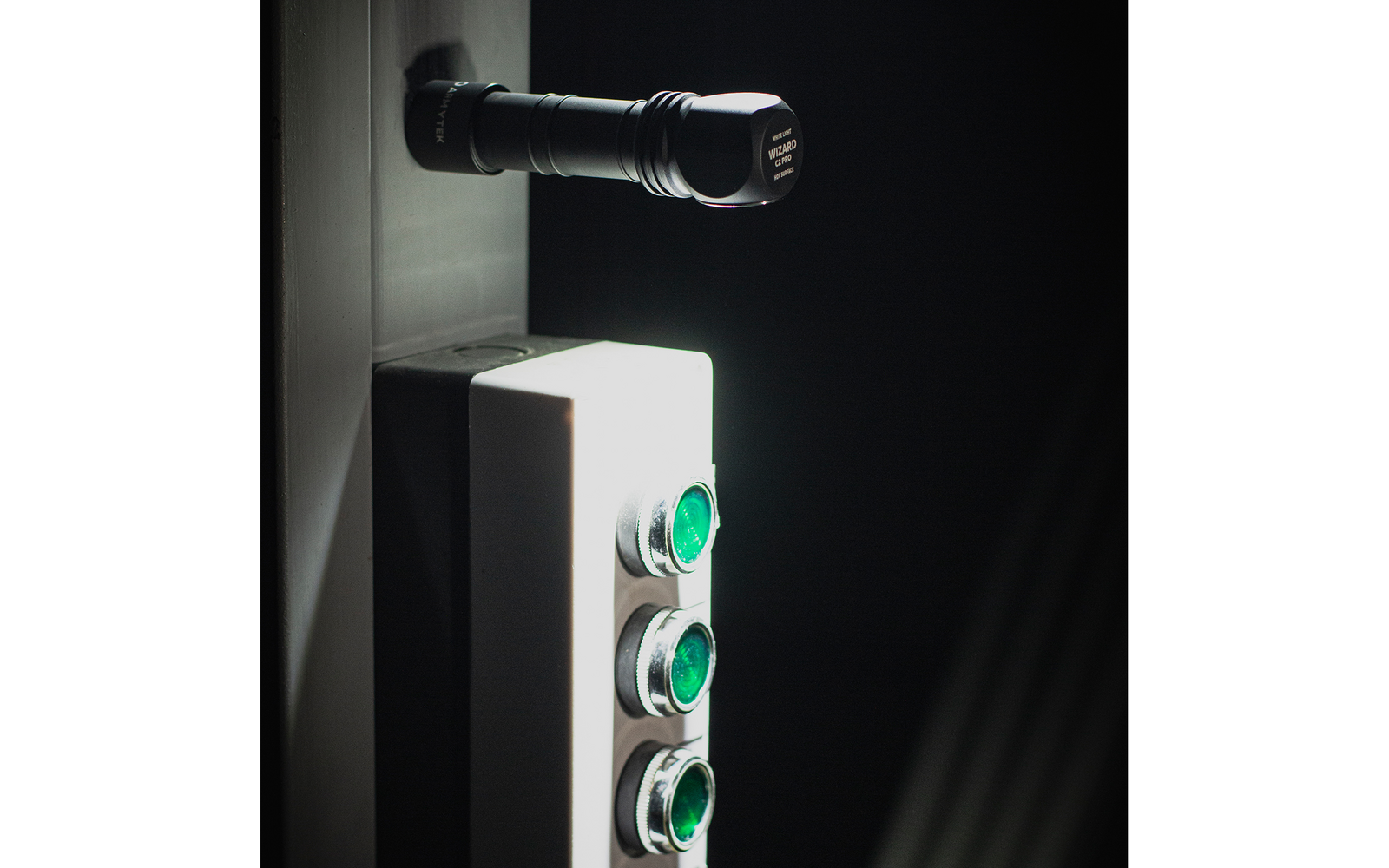 Weiße elektronische Tastatur mit grünen Druckknöpfen an schwarzer Wand