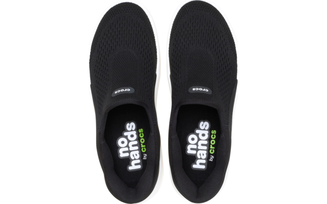 Paar schwarze Slip-on-Schuhe von oben, weiße Sohlen, Innensohlen mit Aufdruck 'no hands by crocs'
