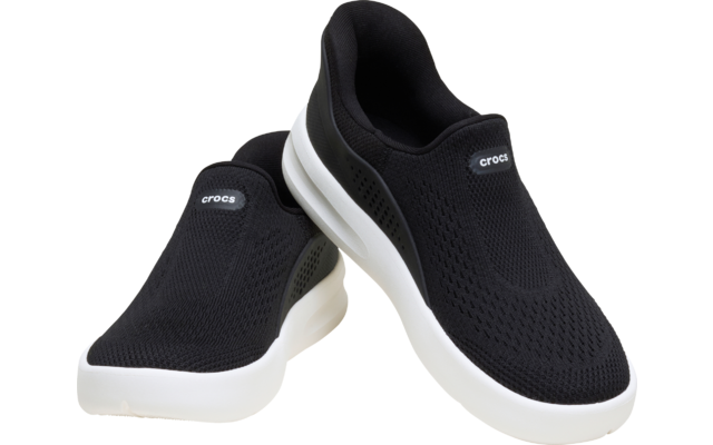 Ein Paar schwarze Slip-on-Schuhe mit gestrickter Oberfläche, weißen Sohlen und sichtbarem "crocs"-Logo auf der Oberseite