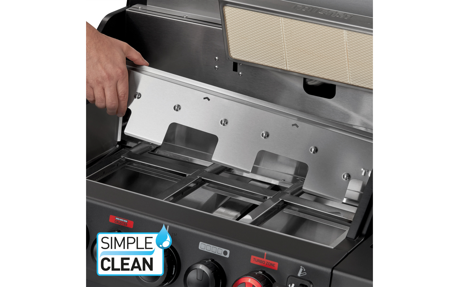 Hand hält ein Metallblech im geöffneten Edelstahl-Innenraum eines Gasgrills; sichtbare Brennerroste, hellbeiger Fettfilter oben, drei Drehknöpfe (schwarz/rot) und Logo 'SIMPLE CLEAN' mit Wassertropfen unten links