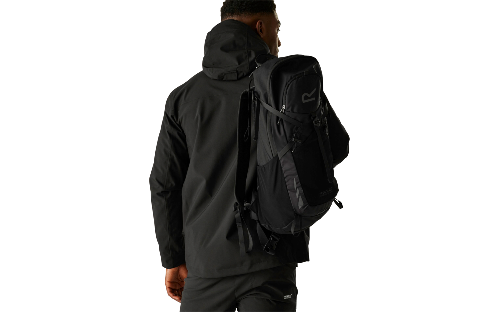 Person in schwarzer Outdoorjacke und schwarzem Rucksack, Rückenansicht