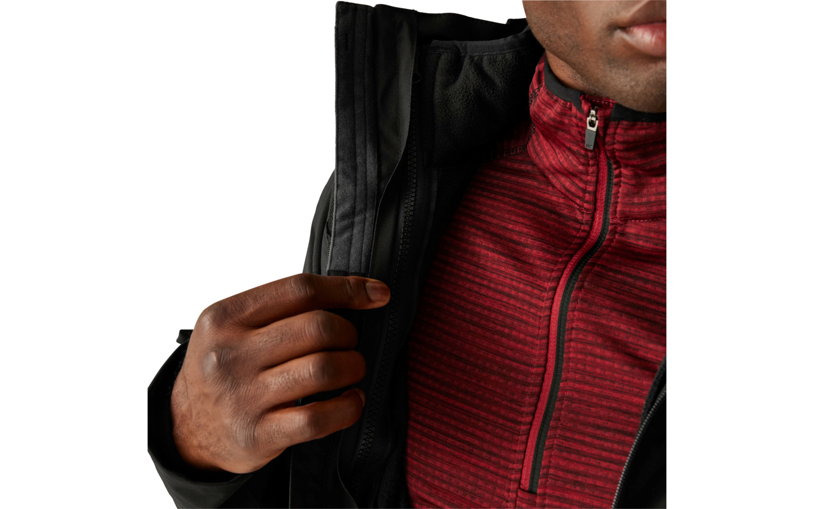 Hand hält den Reißverschluss einer schwarzen Jacke, darunter ein rotes, gestreiftes Shirt