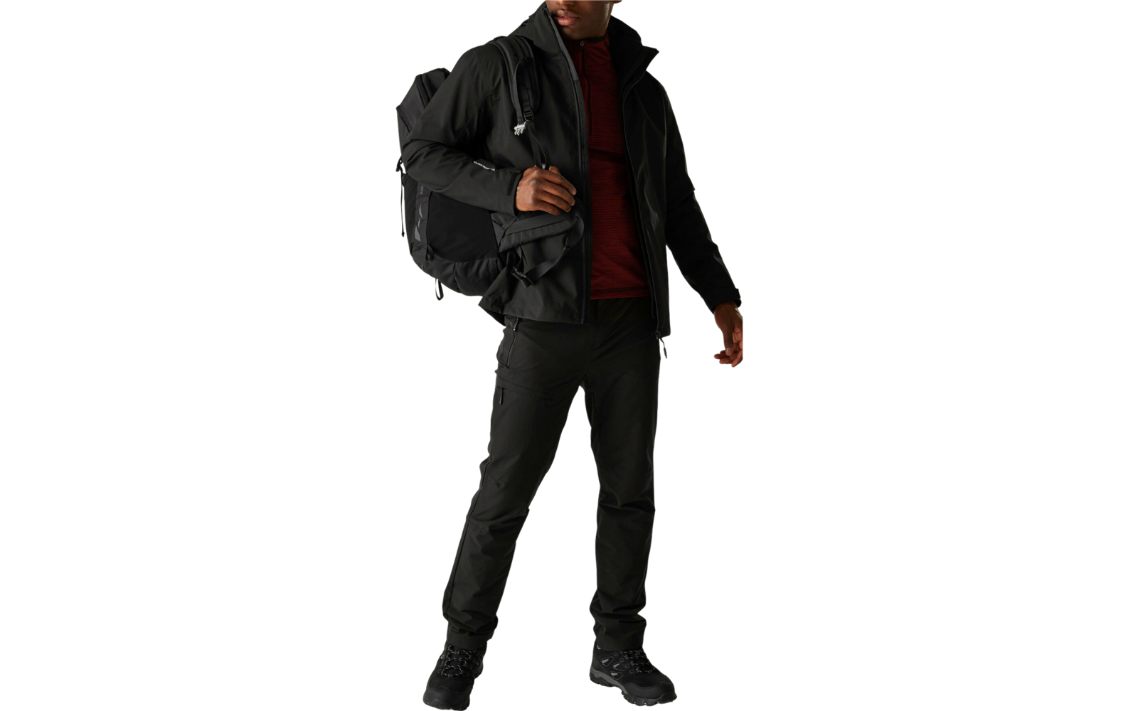 Person trägt schwarze Jacke, rotes Hemd und schwarze Hose, steht