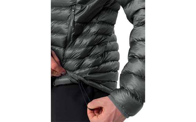 Gesteppte graue Jacke, Hände ziehen Saumkordel, sichtbarer Reißverschluss, schwarze Hose, weißer Hintergrund